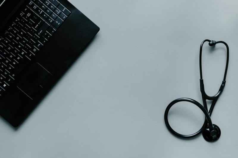 a black laptop and a black stethoscope