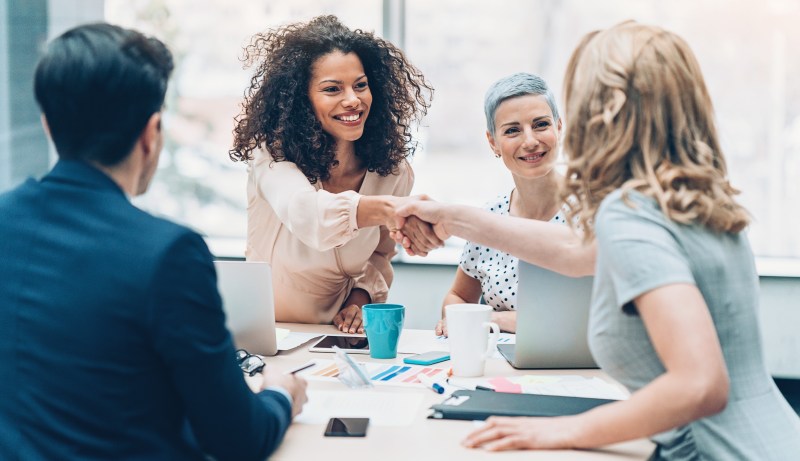 Empresarios dándose la mano en una reunión