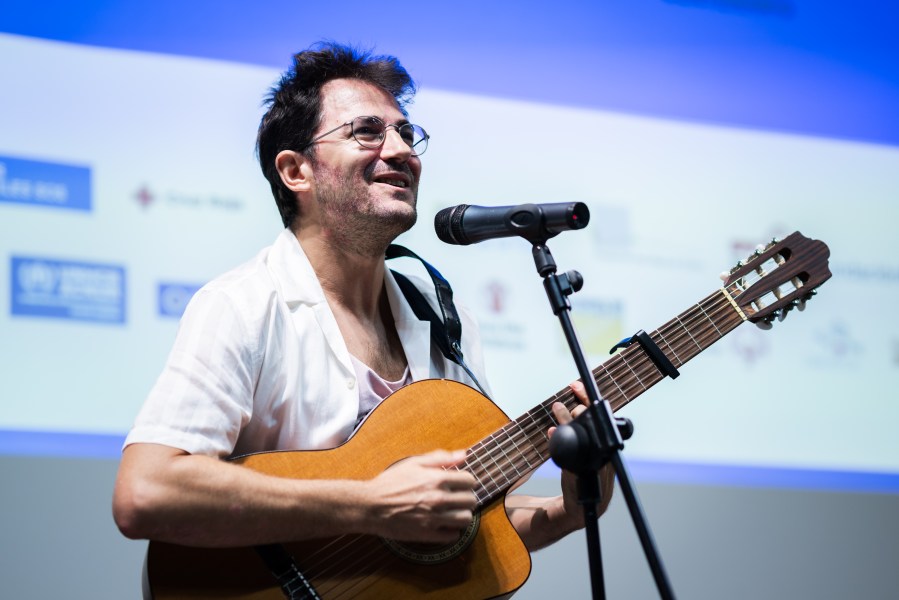 El músico Guillem Roma actuando durante entrega de la recaudación a las ONG.