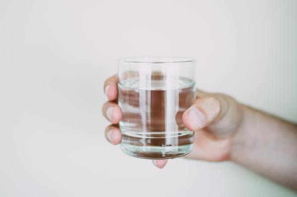 Mano sosteniendo un vaso de agua